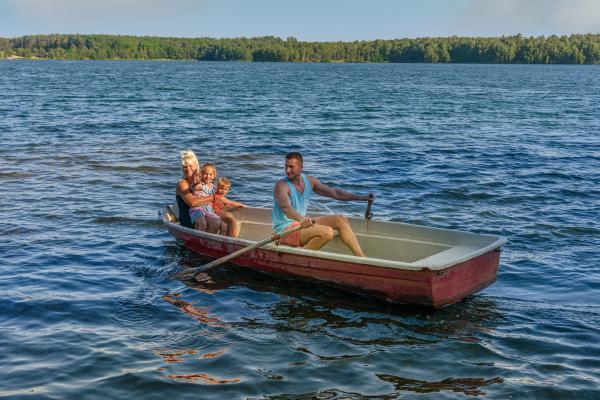 Family excursion by rowing boat on Bergwitz lake
